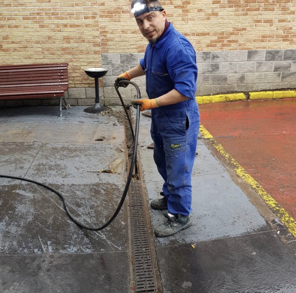 Technicien réalisant un débouchage de canalisation à Bruxelles avec matériel professionnel